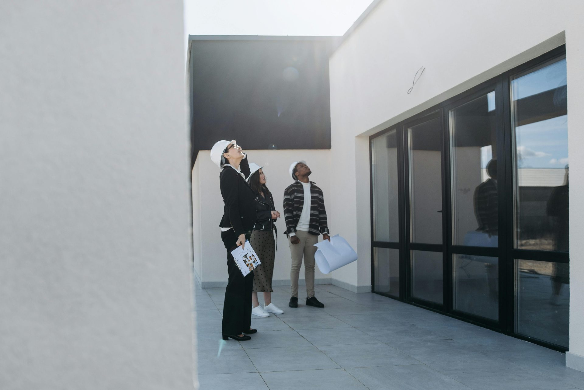 Eine Gruppe von Immobilienmaklern begutachtet tagsüber ein modernes Gebäude.